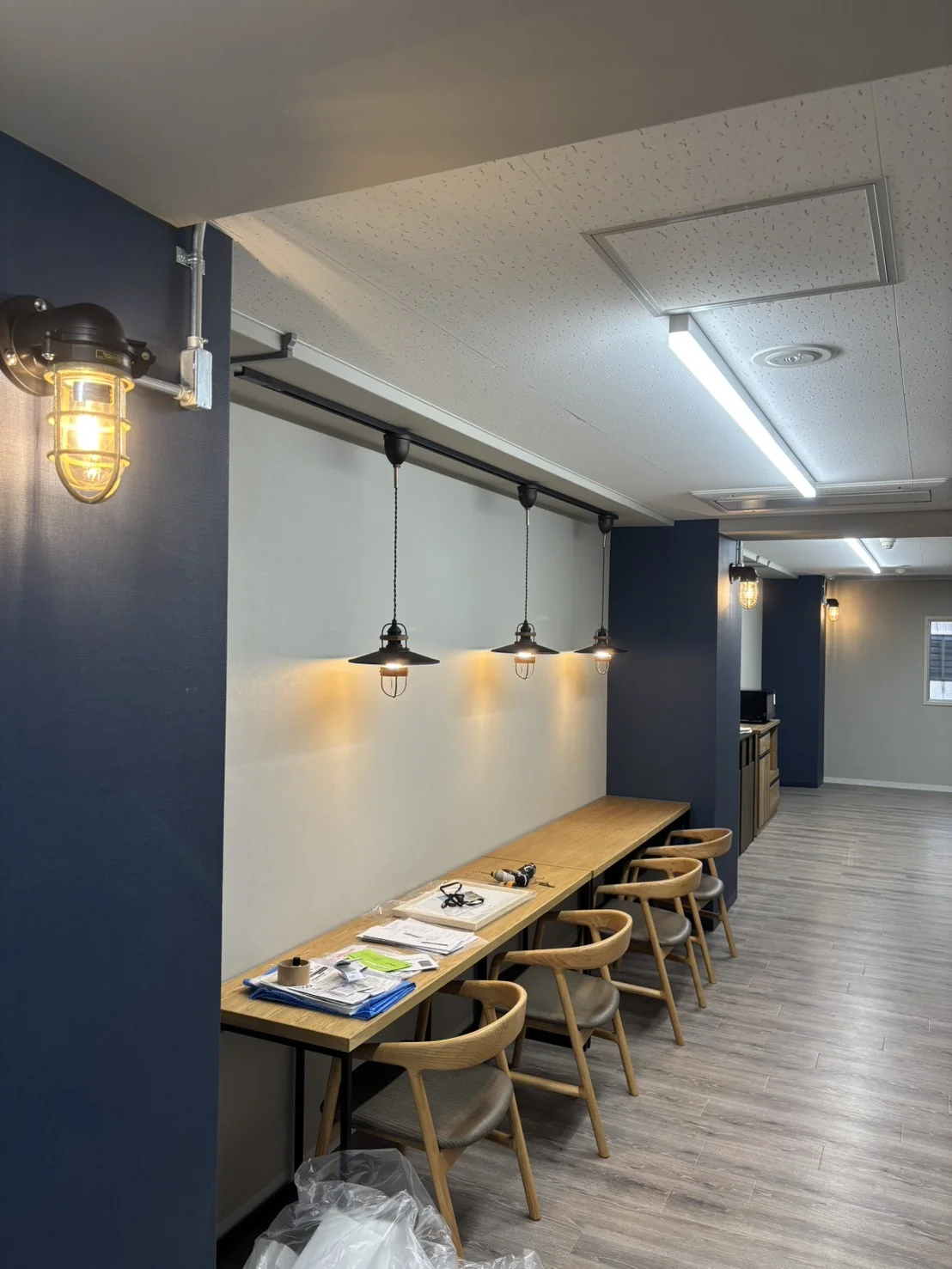 ネイビー壁と真鍮照明の店舗内装